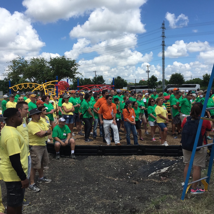 Hundred of volunteers after a day of building a new playground for Wheatley Middle School